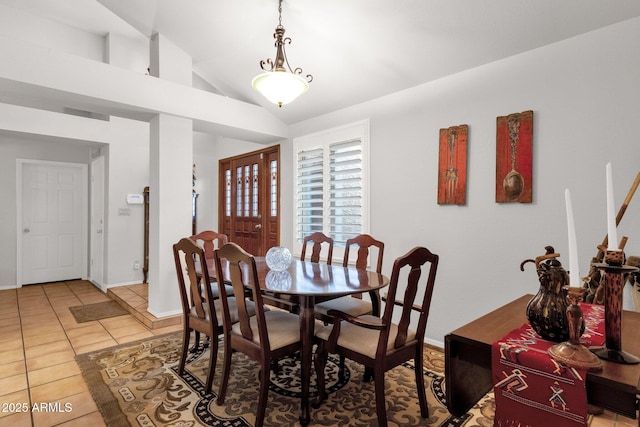 dining area with tile patterned flooring and vaulted ceiling