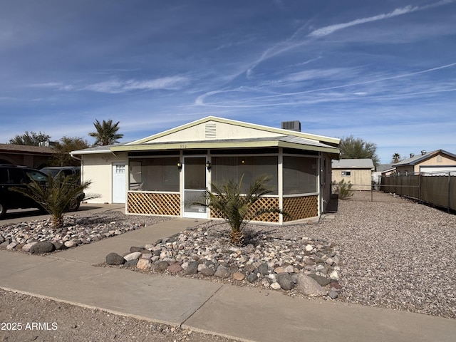 manufactured / mobile home with fence, a sunroom, and stucco siding