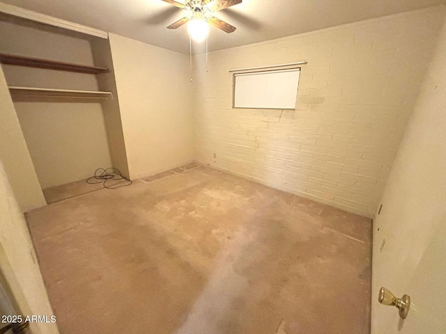 interior space featuring brick wall, carpet, a ceiling fan, and a closet