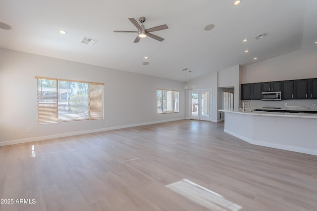 unfurnished living room with visible vents, recessed lighting, and ceiling fan with notable chandelier