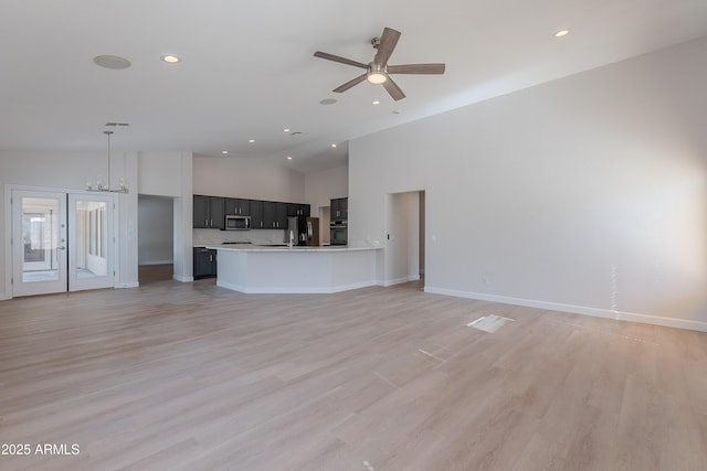 unfurnished living room with recessed lighting, a ceiling fan, lofted ceiling, and light wood-style floors