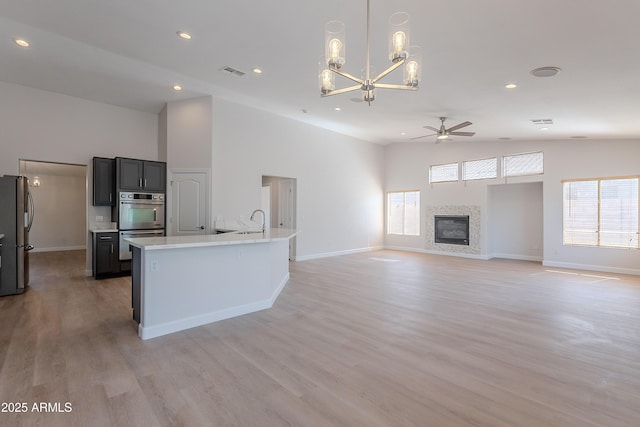 kitchen featuring plenty of natural light, stainless steel appliances, light countertops, ceiling fan with notable chandelier, and visible vents