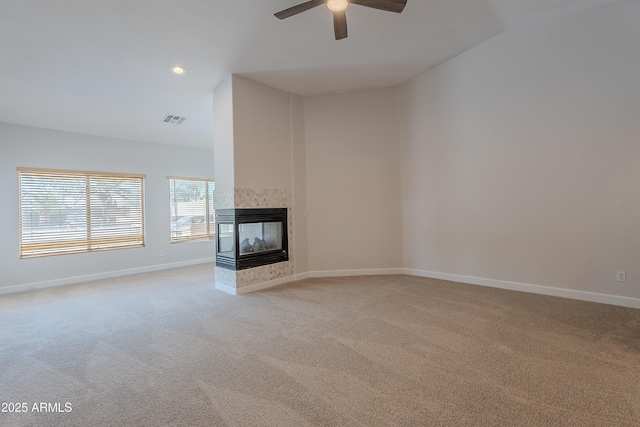 unfurnished living room featuring a ceiling fan, visible vents, light colored carpet, and baseboards