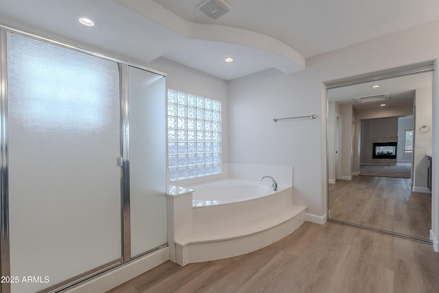 full bathroom with wood finished floors, visible vents, a shower stall, and a bath