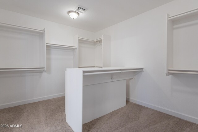 spacious closet featuring visible vents and light carpet