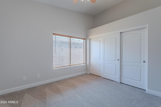 unfurnished bedroom featuring a closet, baseboards, a ceiling fan, and carpet floors