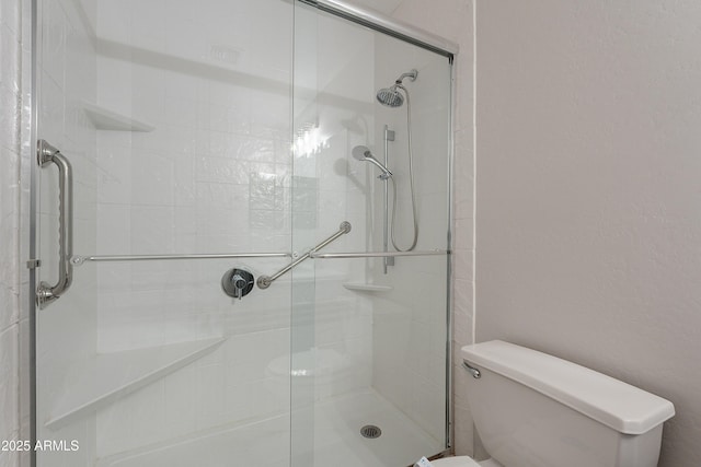 bathroom featuring a shower stall and toilet