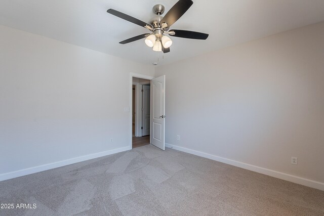 empty room featuring ceiling fan, light carpet, and baseboards