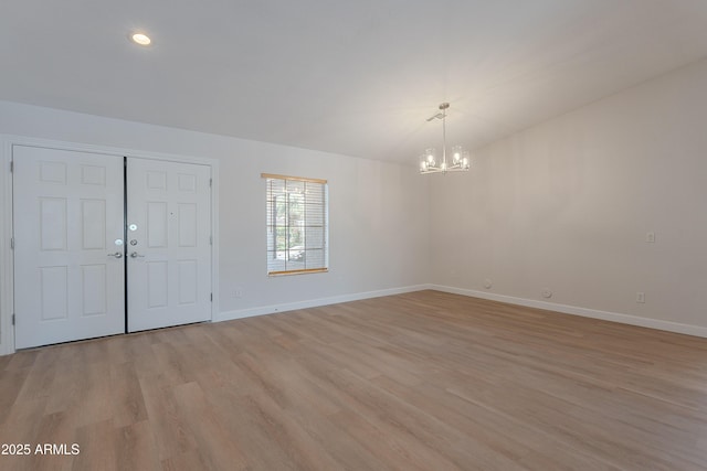 entryway with recessed lighting, a notable chandelier, baseboards, and light wood-type flooring