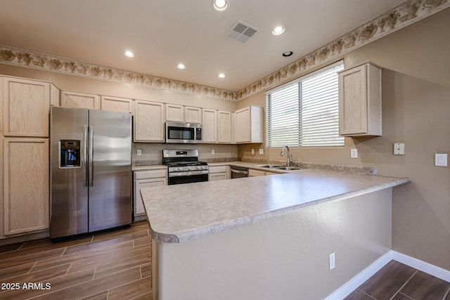 125 N 22nd Pl Unit 14, Mesa, AZ 85213 - kitchen featuring stainless steel appliances, a peninsula, a sink, light countertops, and wood tiled floors