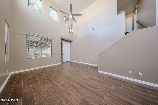125 N 22nd Pl Unit 14, Mesa, AZ 85213 - unfurnished living room with wood finished floors, a ceiling fan, baseboards, and a towering ceiling