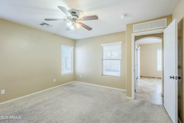 carpeted spare room featuring ceiling fan