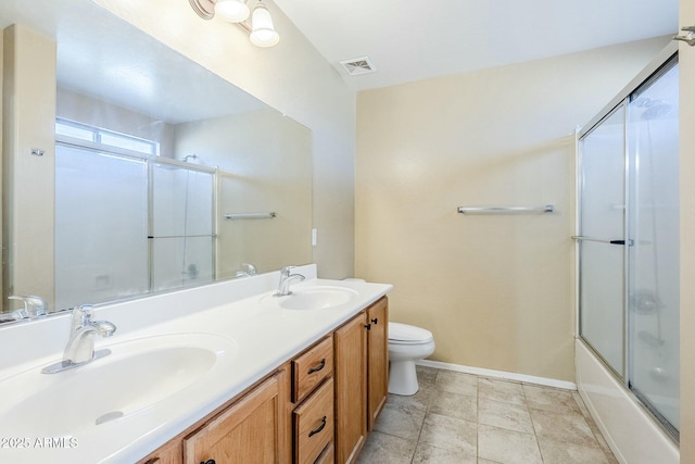 full bathroom featuring combined bath / shower with glass door, vanity, and toilet