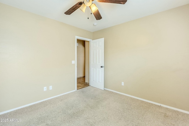 spare room with ceiling fan and light colored carpet