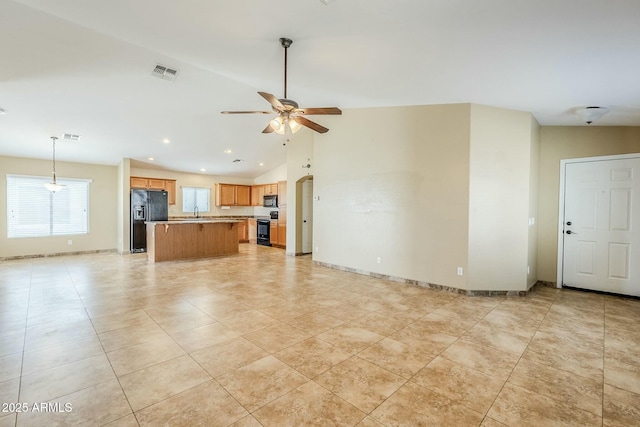 unfurnished living room with sink, lofted ceiling, ceiling fan, and light tile patterned floors