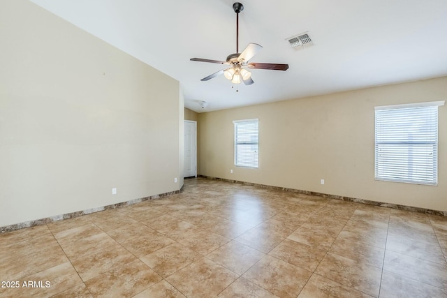 spare room featuring vaulted ceiling, ceiling fan, and light tile patterned floors