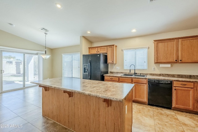 kitchen featuring hanging light fixtures, black appliances, sink, vaulted ceiling, and a breakfast bar area