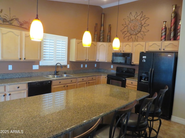 kitchen with light stone countertops, sink, hanging light fixtures, and black appliances