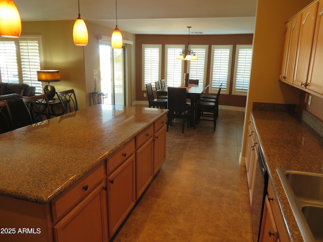 kitchen with sink, dishwasher, a kitchen island, pendant lighting, and tile patterned flooring