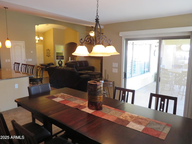 dining space with hardwood / wood-style flooring, lofted ceiling, and a chandelier