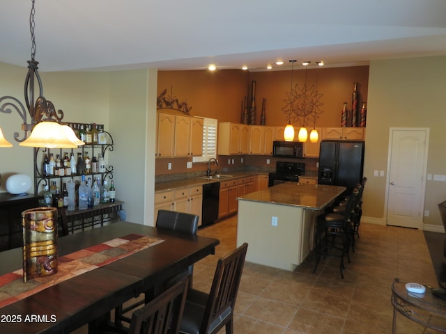 kitchen with pendant lighting, sink, a breakfast bar area, black appliances, and a kitchen island