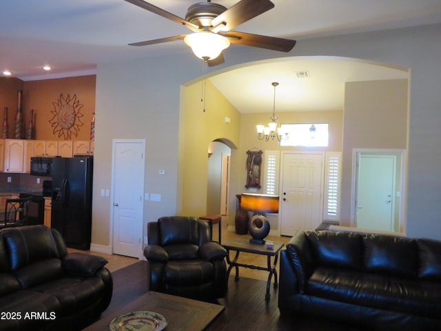 living room with hardwood / wood-style floors, a towering ceiling, and ceiling fan with notable chandelier