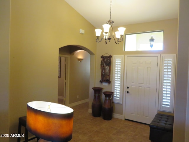 entryway with plenty of natural light, a notable chandelier, and high vaulted ceiling