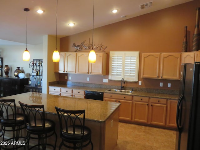 kitchen with sink, a breakfast bar area, decorative light fixtures, a kitchen island, and black appliances