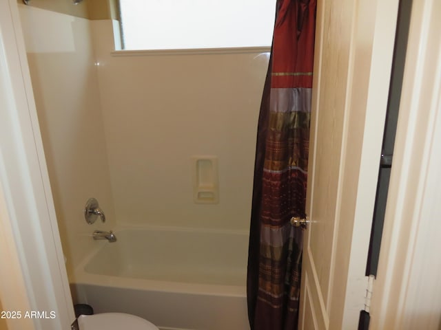 bathroom with shower / tub combo and toilet