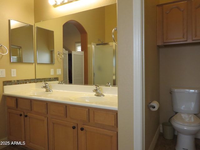 bathroom featuring vanity, toilet, and an enclosed shower