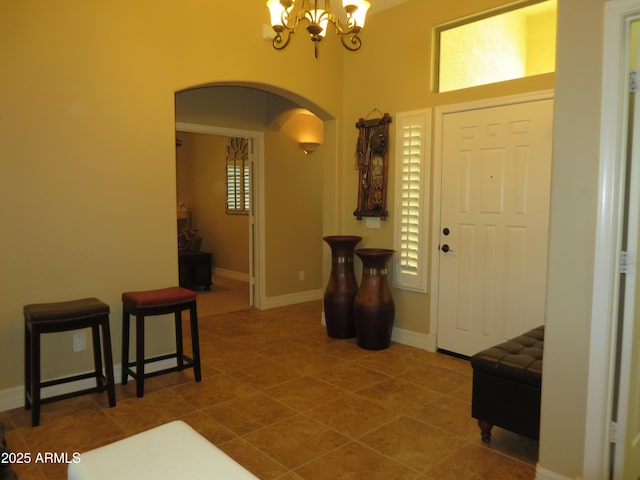 tiled entryway with a notable chandelier