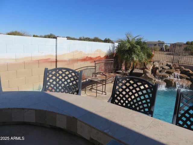 view of patio featuring pool water feature and a fenced in pool