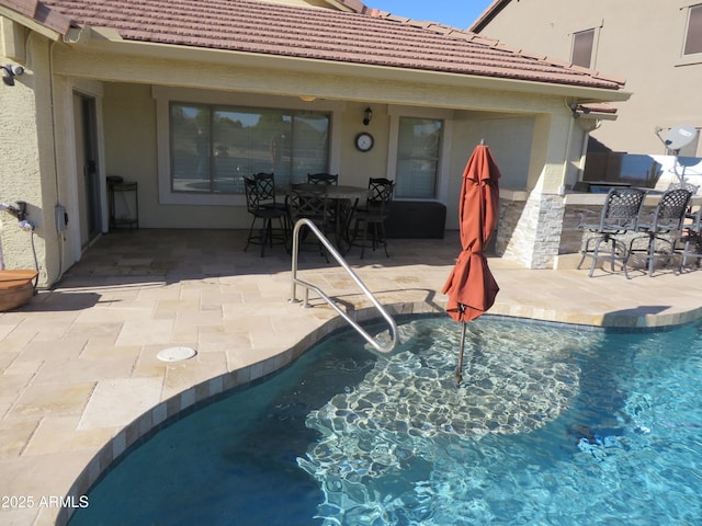 view of swimming pool with a patio and a bar