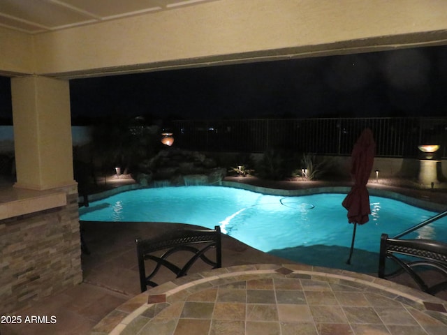 pool at twilight featuring a patio