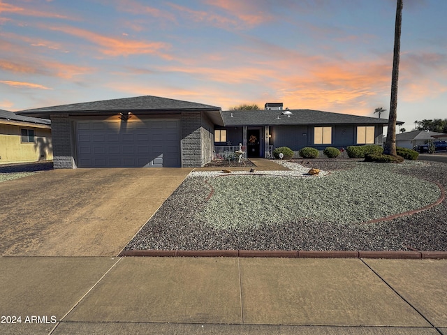 view of front of property featuring a garage, brick siding, and concrete driveway