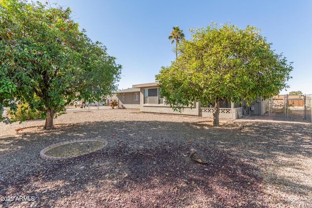 view of yard featuring a sunroom, fence, and a gate