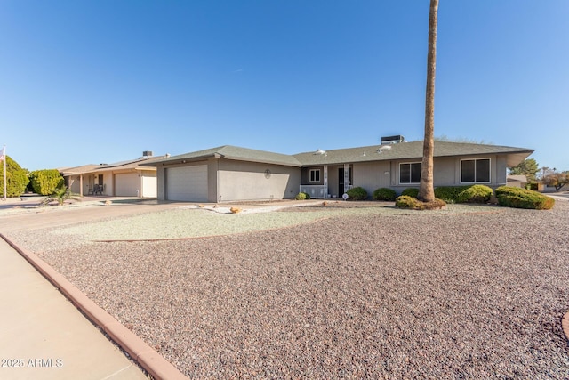 ranch-style home featuring an attached garage, driveway, and stucco siding