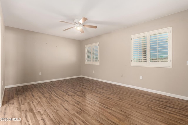 unfurnished room featuring baseboards, wood finished floors, and ceiling fan