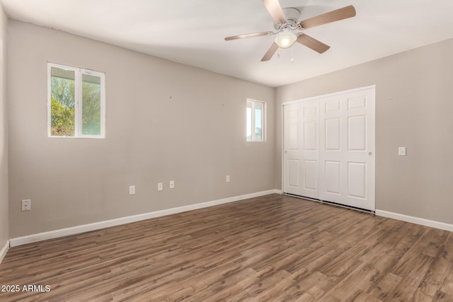 unfurnished bedroom featuring a ceiling fan, wood finished floors, a closet, and baseboards