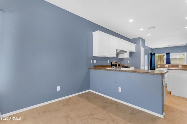 11630 W Jefferson St, Avondale, AZ 85323 - kitchen with under cabinet range hood, a peninsula, white cabinets, range, and light tile patterned flooring