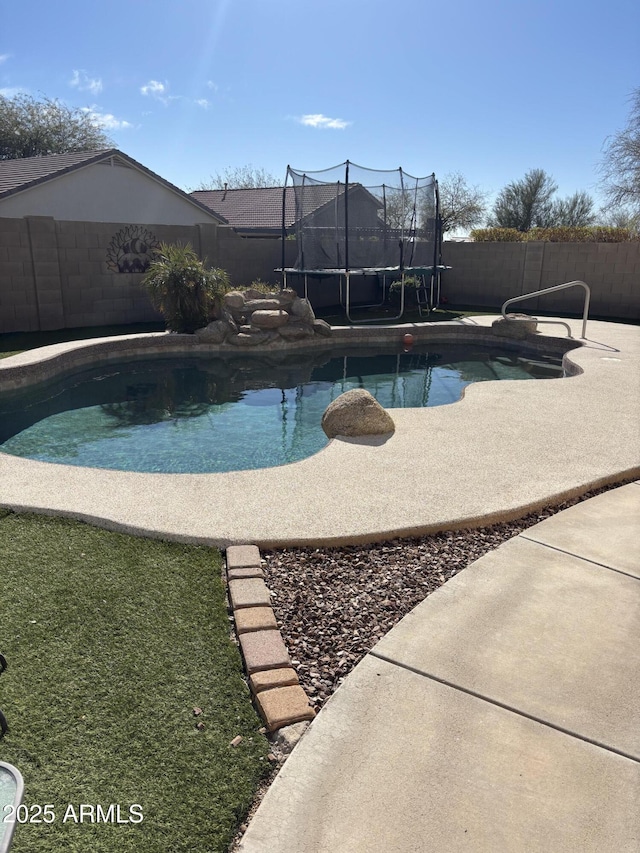 view of pool featuring a fenced backyard, a trampoline, and a fenced in pool