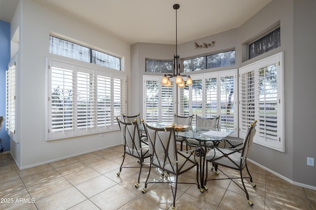 dining area with light tile patterned floors and an inviting chandelier