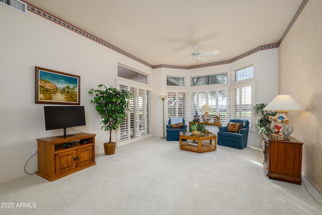 living area featuring light colored carpet and ceiling fan