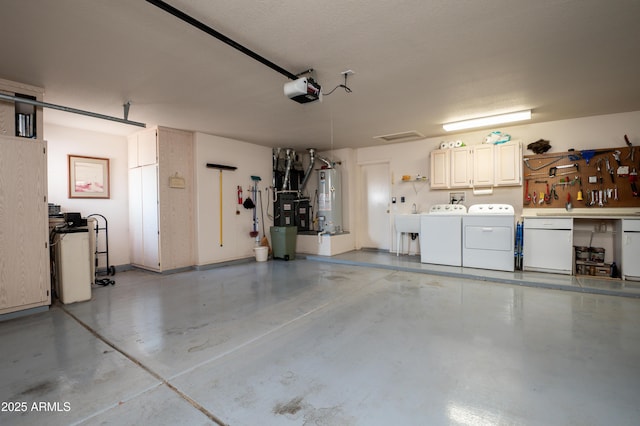 garage featuring washer and dryer, sink, and water heater