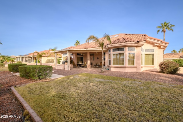 back of property featuring a patio area and a lawn