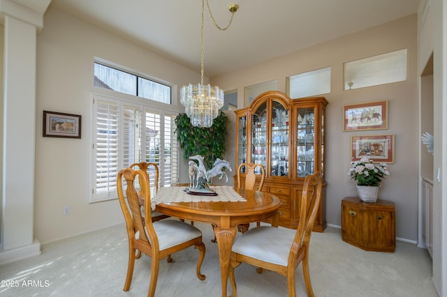 dining room featuring light colored carpet and a chandelier