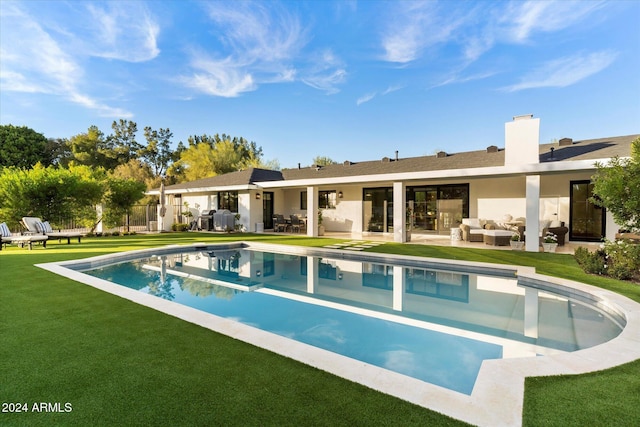 view of pool with a lawn, outdoor lounge area, and a patio area