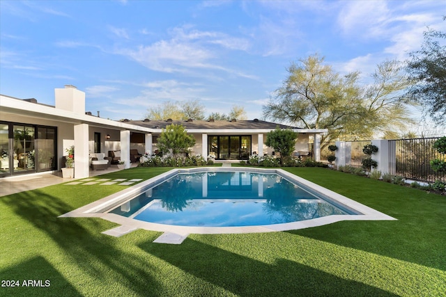 view of swimming pool with a patio, an outdoor hangout area, and a lawn