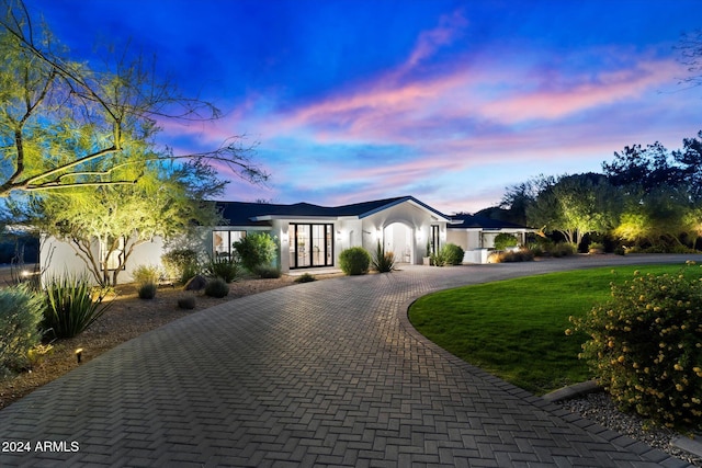 view of front of home with a lawn and french doors