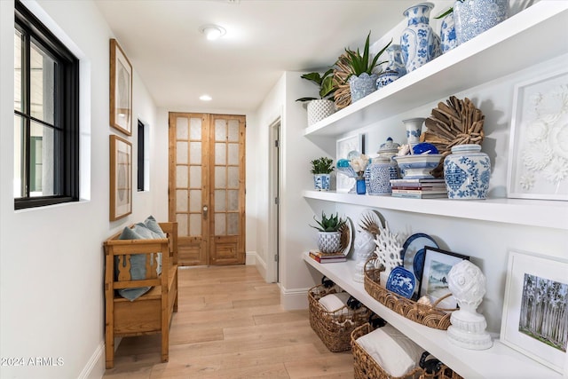 corridor featuring light hardwood / wood-style floors and french doors